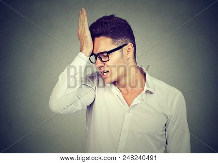 Man, Slapping Hand On Head Having Regrets Isolated On Gray Background. Negative Human Emotion Feelin