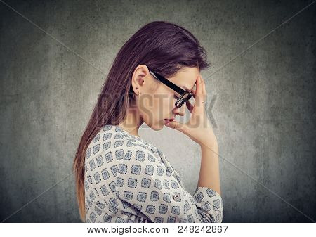 Side View Of Casual Girl In Glasses Holding Hand On Forehead In Deep Thoughts Looking Miserable With
