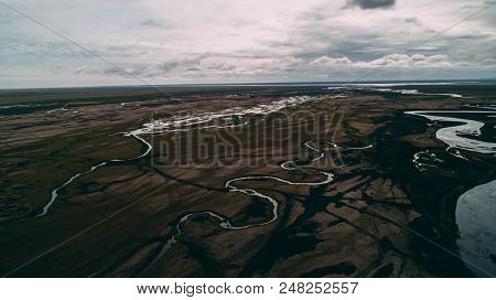 Aerial View Of River In Black Sand With Many Junctions