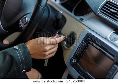 A Girl Inserts The Ignition Key, Sitting In Her Car, Ready To Start The Movement.