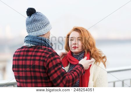 Rude Women With Red Woolen Scarf And Guy In Red Jacket. Man Dressing Red Scarf On Woman. Rouge Woman
