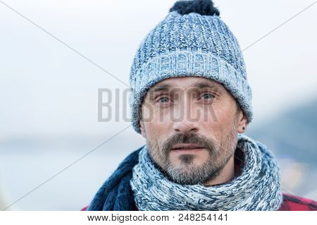 Portrait Of White Man In Winter Knitted Hat And Scarf. Urban White Male On Street In Winter Hat. Clo