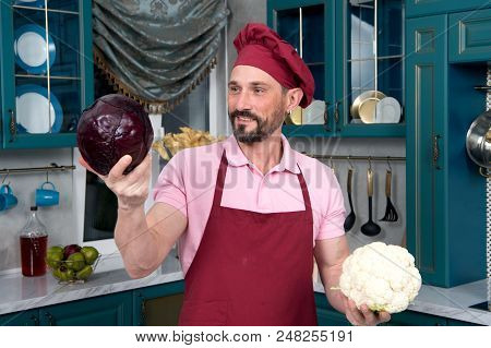 Man Chooses Vegetables For Cooking. Happy Chef Make Chose Between Fresh Red Cabbage And Cauliflower 