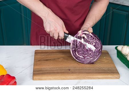 Close Up Of Cutting Half Of Red Cabbage. Closeup Of Man Hands With Knife And Red Cabbage. Red Cabbag
