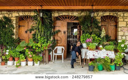 Omodos, Cyprus. May 2018. A View Of A Local Man Sitting In His Beautiful Garden In The Traditional V