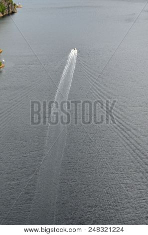 
A motor boat in the fjord goes along the border of Norway and Sweden.June 18,2018.Ostfold Region,Norway