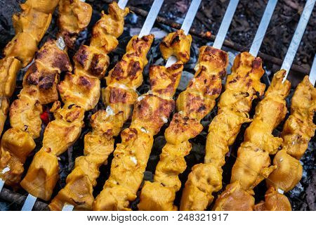 Grilled Kebab Cooking On Metal Skewer Closeup. Roasted Meat Cooked At Barbecue. Bbq Fresh Beef Meat 