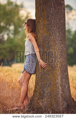 Cute Smiley Girl Embracing The Oak Tree In Nature.