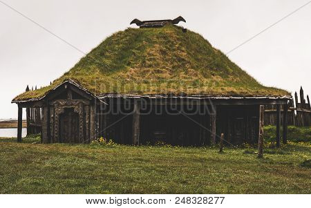 Old Viking Village In Iceland With Foggy Hill. Old Wooden Buildings Covered Grass