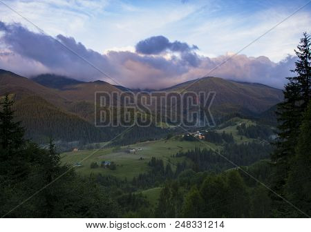 Photo Of Mountain Village In The Summer Under Beautiful Cloudy Sky. Ukraine, Carpathians, Dzembronia