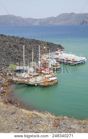 Many Wooden Ships On Port Of Nea Kameni Volcanic Island Near Santorini