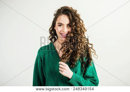 Fashion Woman In Green Sweater. Fashion Look And Beauty Concept. Girl With Curly Hair At Hairdresser
