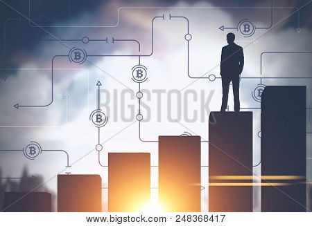 Businessman Standing On A Giant Bar Chart In A Morning City. Bitcoin Immersive Interface In The Sky.