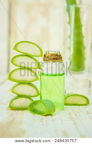 Aloe Vera Extract In A Small Bottle And Pieces On The Table. Selective Focus.