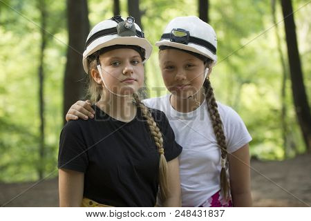 Two Teen Girls Speleologists In Helmets In The Forest At Sunny Day, Horizontal