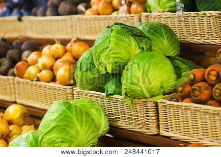 Fresh Vegetables In Wicker Baskets On The Counter Of A Small Vegetable Market. Ingredients For Salad