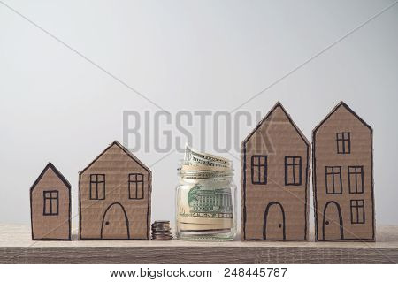 Property Investment And House Mortgage Financial Concept With Money And Cardboard Houses