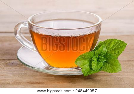Glass Cup Of Tea With Mint Leaves On Wooden Table