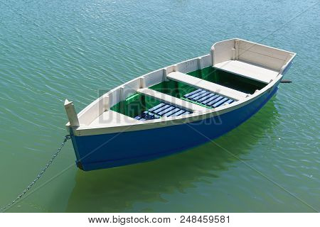 Bright Blue Rowing Boat On The Emerald Water Of The Lake