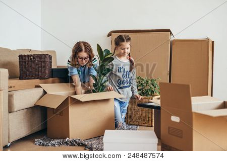 Woman And Her Daughters Moving In New Home.