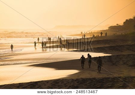 Silhouettes Of People At Sunset On Kuta Beach In Bali, Indonesia