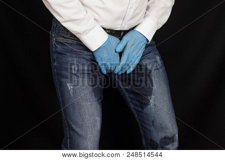 A Man In Medical Gloves Holds On To The Groin, Pain In The Perineum, Prostatitis, Wet Pants