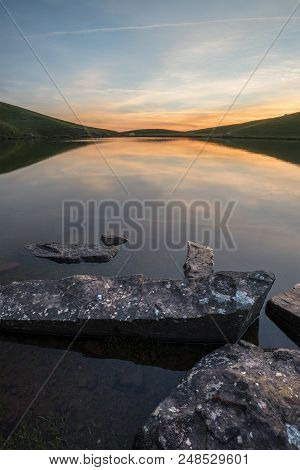 Beautiful Summer Sunrise Landscape Of Colors Reflected In Llyn Cwm Lwch In Brecon Beacons National P
