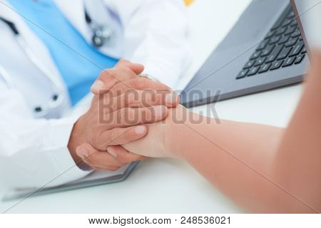 Hand Of Doctor Reassuring Her Female Patient. Medical Ethics And Trust Concept