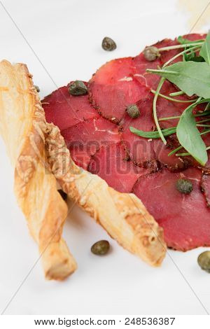 Delicious Dried Beef Basturma With Cheese, Mozzarella, Potatoes And Spinach Leaves On A Plate On Bla