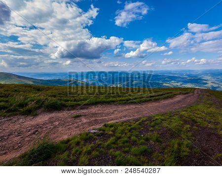 A Dirt Road In The Middle Of A Blue Sky With White Clouds. A Pleasant Place For Walking And Solitude