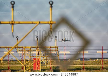 Traffic At The Airport. Airplane During Take Off Over Landing Lights (view Through The Fence).