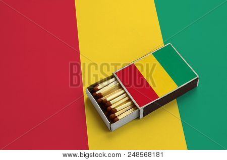 Guinea Flag  Is Shown In An Open Matchbox, Which Is Filled With Matches And Lies On A Large Flag.
