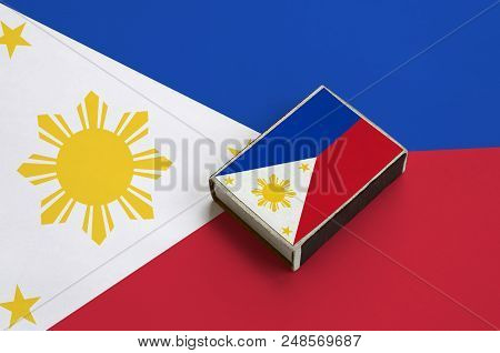 Philippines Flag  Is Pictured On A Matchbox That Lies On A Large Flag.