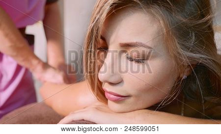 Massage Concept. Portrait Of Beautiful Young Woman Reciving Relxing Massage At Luxury Spa Salon With