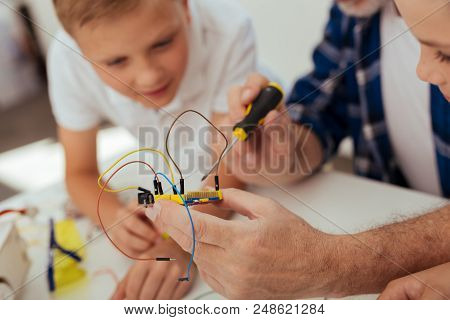 Digital Development. Electronic Microscheme With Wires Being In Hands Of A Nice Positive Man