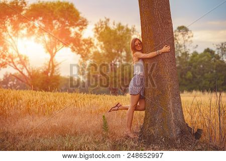 Cute Smiley Girl Embracing The Oak Tree In Nature.