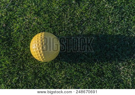 Yellow Golf Ball With Its Shadow On The Grass Of A Course Near Santa Cruz On The Island Of Tenerife