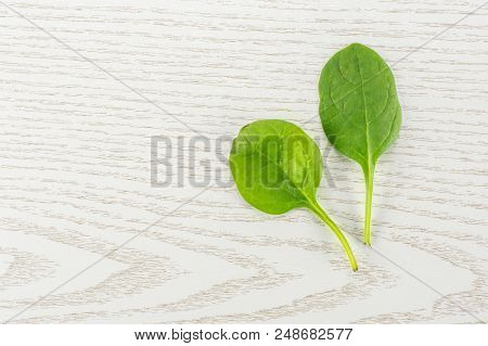 Fresh Baby Spinach Top View On Grey Wood Background Two Green Single Leaves