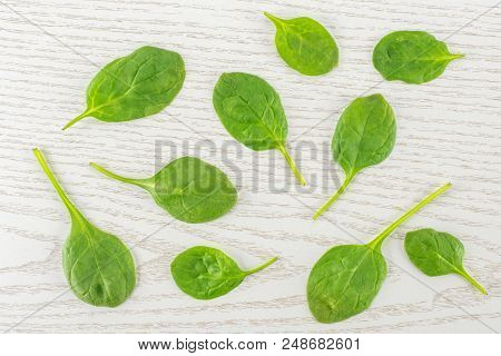 Fresh Baby Spinach Leaves Top View On Grey Wood Background