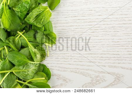 Fresh Baby Spinach Leaves Top View On Grey Wood Background Left Corner