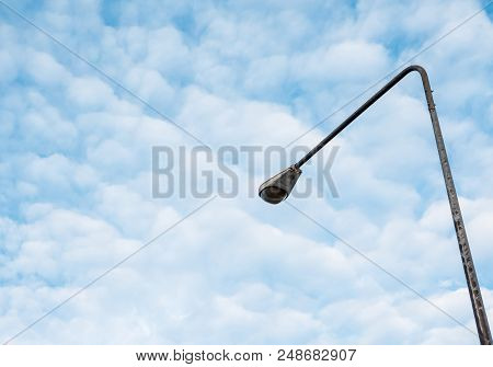 High Street Light Pole Under The Couldy Sky Near The Urban Area.(copy Space).