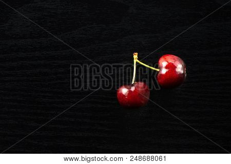 Group Of Two Whole Sweet Bright Red Cherry Flatlay On Black Wood