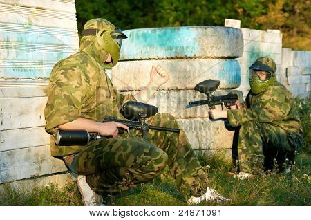Prootective iki paintball spor oyuncu koyar ve hedefleyen ve shoting dışarıda silahla maske