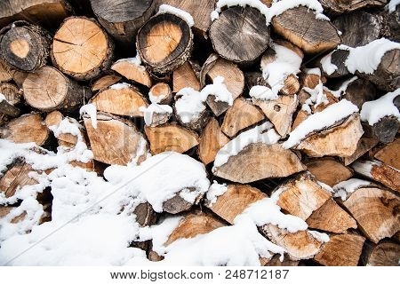 Heap Of Oak Firewood Covered With Snow, Preparation For The Winter Season, Background