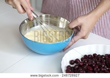 Young Woman Cooking In Kitchen.clafoutis Cherry Pie. Preparation Of A French Pie With Cherries