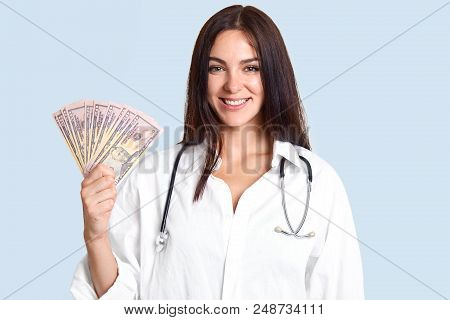 Medicine And Corruption Concept. Happy Young Professional Female Doctor Holds Money In Hands, Happy 
