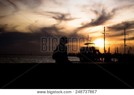 Silhouette Of A Young Woman Against Beautiful Purple Color Of Evening Sky