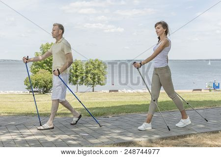 Young Couple Hiking In The Nature Nordic Walking