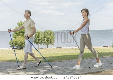 Young Couple Hiking In The Nature Nordic Walking