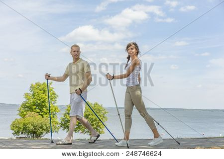 Young Couple Hiking In The Nature Nordic Walking
